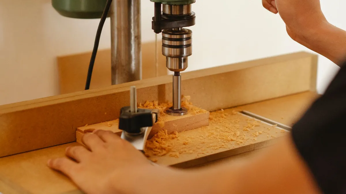 Tischbohrmaschine auf einer Werkbank bereit für Serienbohrungen in Holz