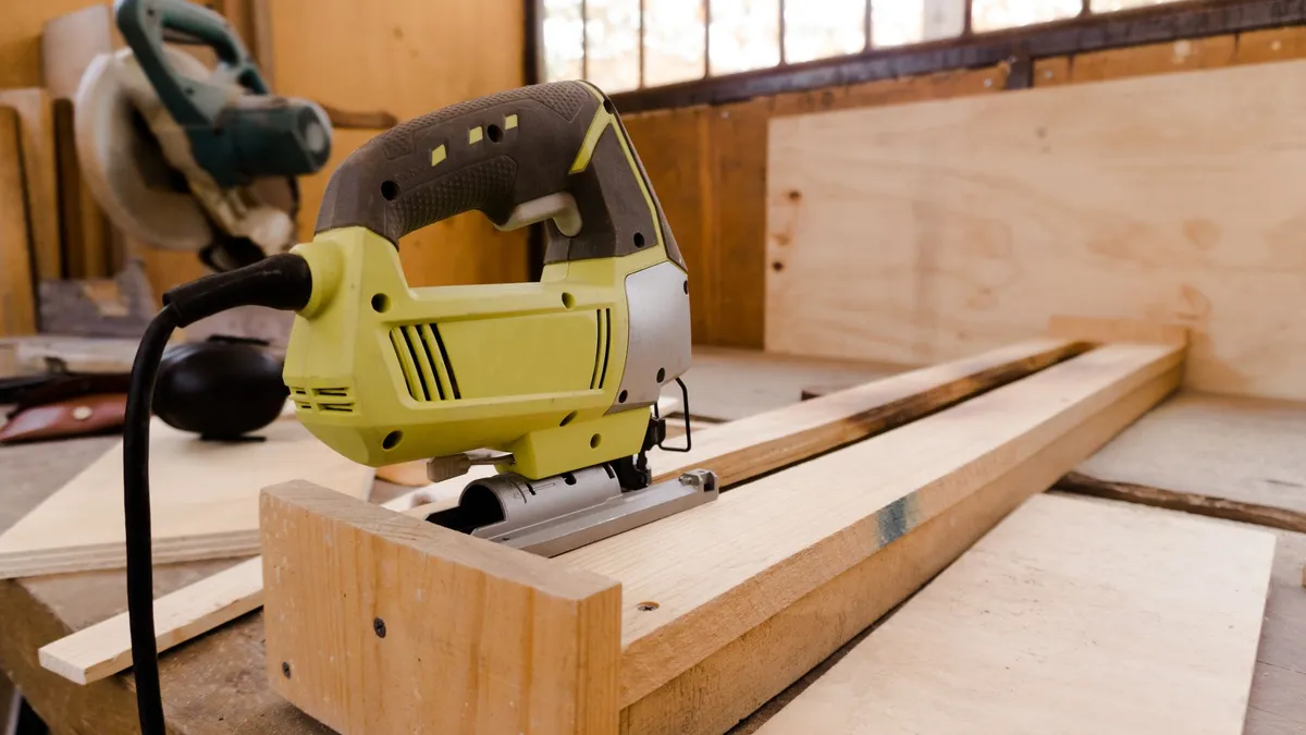 Auflegen der Führungsschiene auf eine Furnierplatte in der Holzwerkstatt